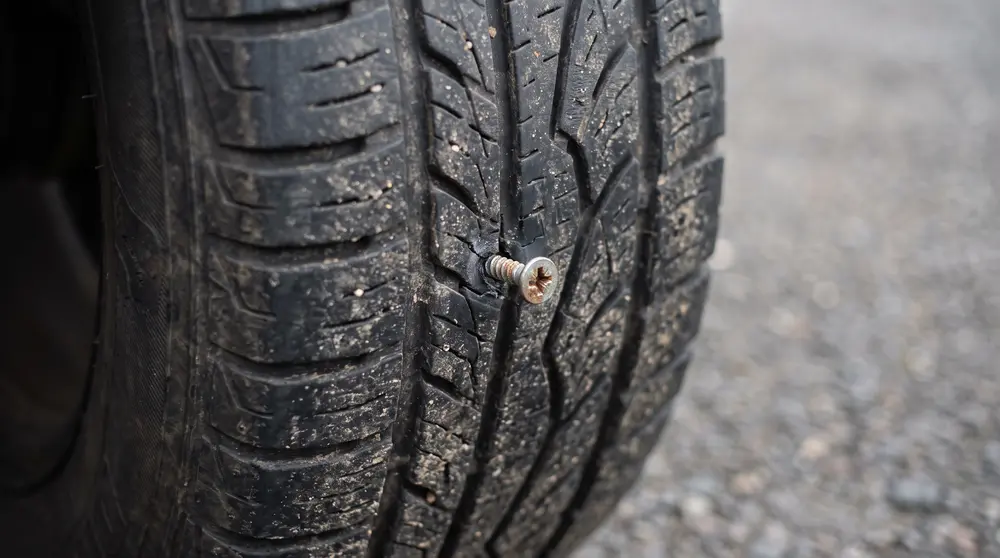 A screw picked up in the central tread of a car tyre - the kind of puncture that can usually be repaired
